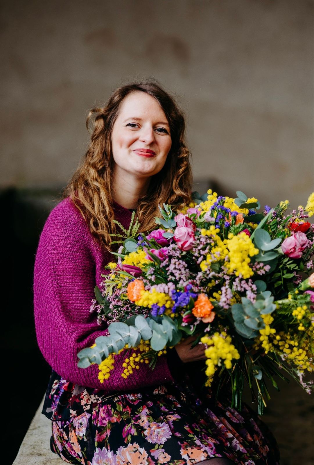 Pauline Wilmouth tenant un grand bouquet de mimosa, roses et eucalyptus